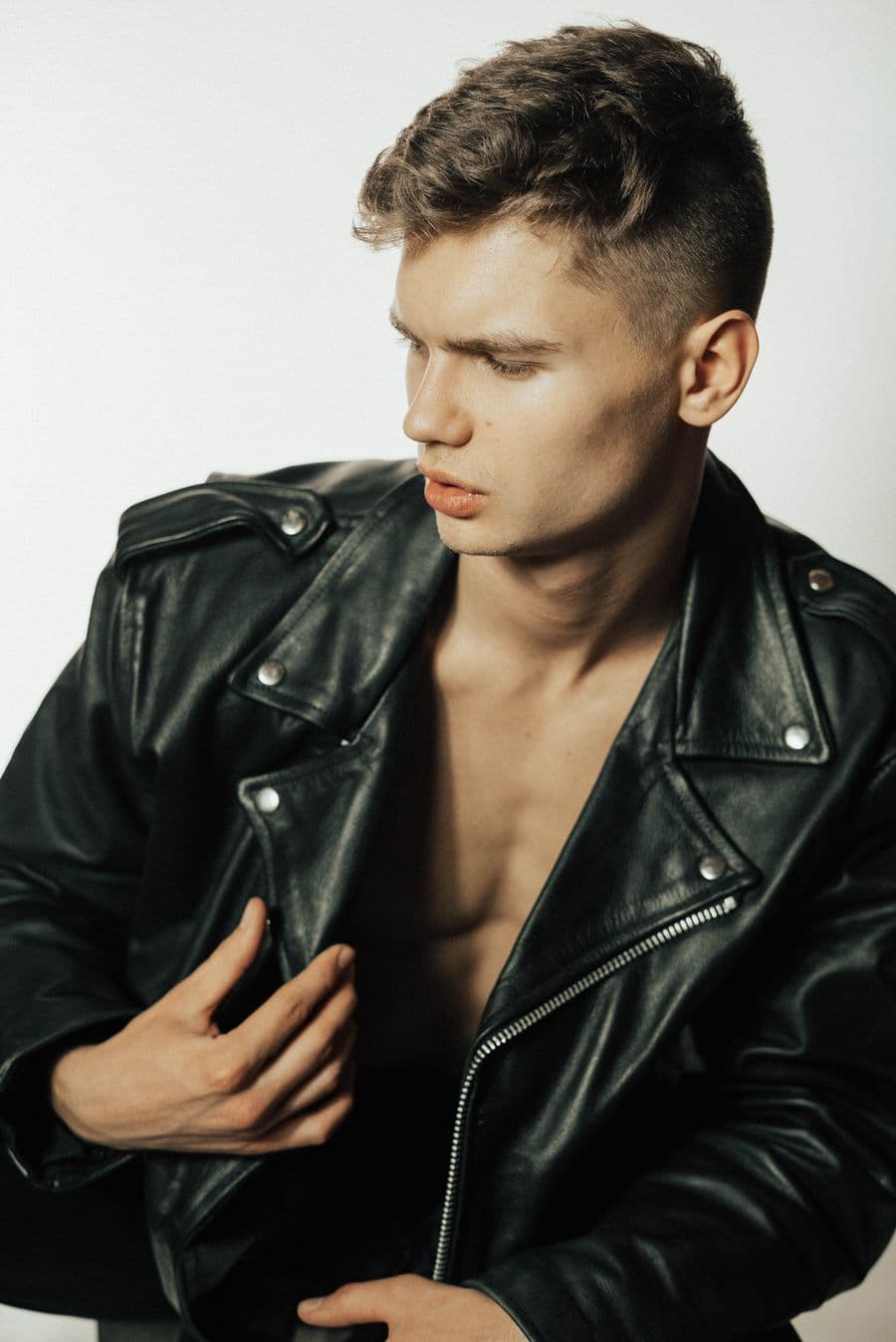 A man in a black leather jacket in soft studio light