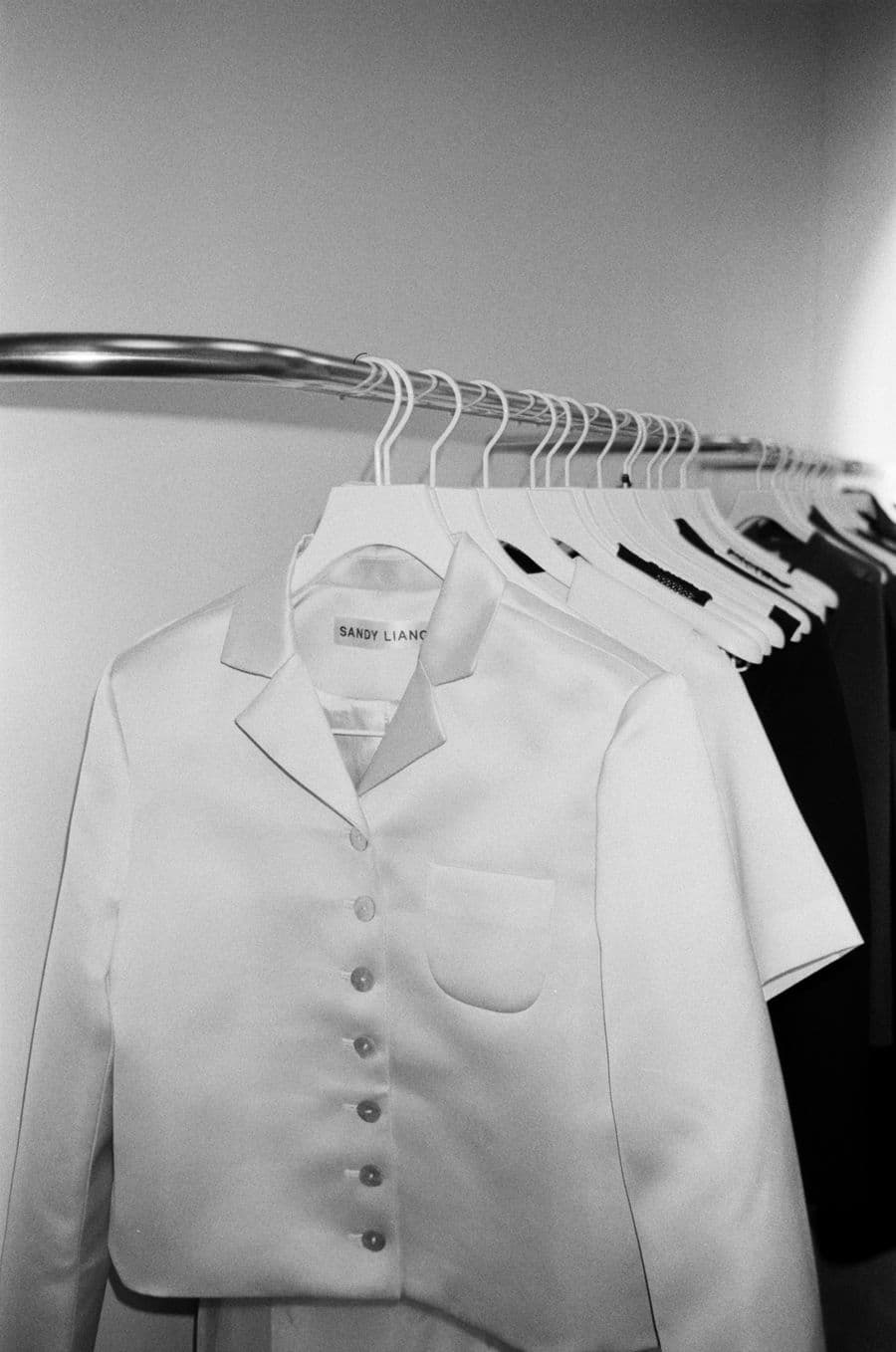 A white jacket hanging on a rail, in black and white
